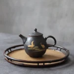 handcrafted black ceramic teapot with gold crane motif front view