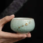 Full product view of handmade celadon crackle glaze chawan tea bowl with gold detailing