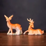 Set of handcrafted ceramic lucky deer tea pets displayed on wooden tea table