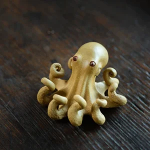 Handmade purple clay octopus tea pet main view on dark wooden tea table