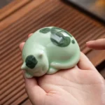 Handcrafted sleeping cat ceramic tea pet main view, mint green lying posture
