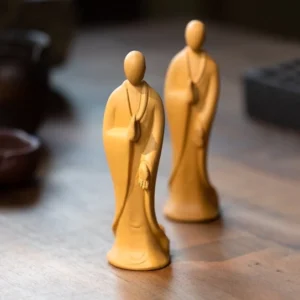 Handcrafted zen monk ceramic tea pet displayed on wooden tea table with traditional tea ware