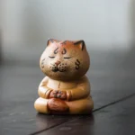 Handcrafted ceramic zen tiger tea pet on dark wooden gongfu tea tray
