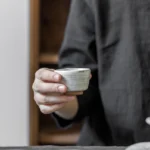 Side view of handmade 50ml black ceramic clay tea tasting cup