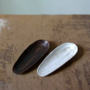 Handmade coarse pottery tea scoop with black wood grain finish full product view