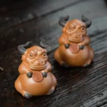 handmade purple clay wealth bull tea pet main view on wooden tea table