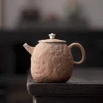 front view of handmade stone shaped 220ml Jingdezhen coarse pottery gongfu teapot with silver accents