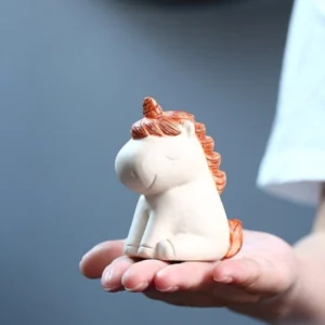 Main view of handmade Yixing clay unicorn tea pet with orange mane and off-white body