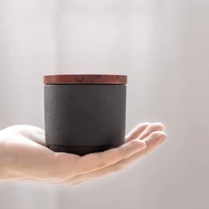 angle view of matte black ceramic tea jar with wooden lid