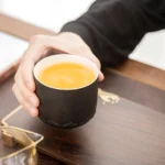 Full view of matte black 200ml porcelain tea cup with lotus carving