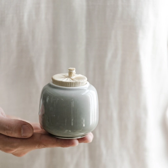 Mini ceramic tea jar for loose tea held in hand to show size comparison