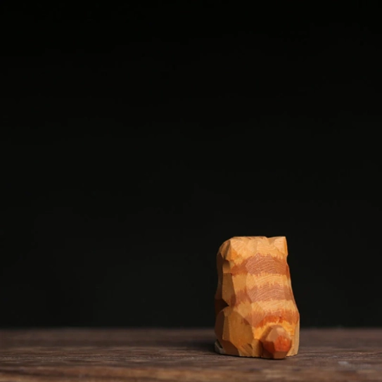 Natural wood grain detail on the bottom of a wooden cat tea pet