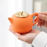 Full set of orange persimmon ceramic tea set with teapot, two cups and serving tray