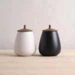 side view of pear shaped frosted ceramic tea jar with bronze metal lid