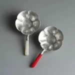 Full plum blossom loose leaf tea strainer with holder set on wooden tea table