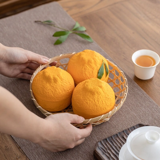 orange ceramic tea strainer placed in small woven basket showing portability