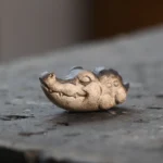 handcrafted purple clay closed-eye crocodile tea pet on tea tray