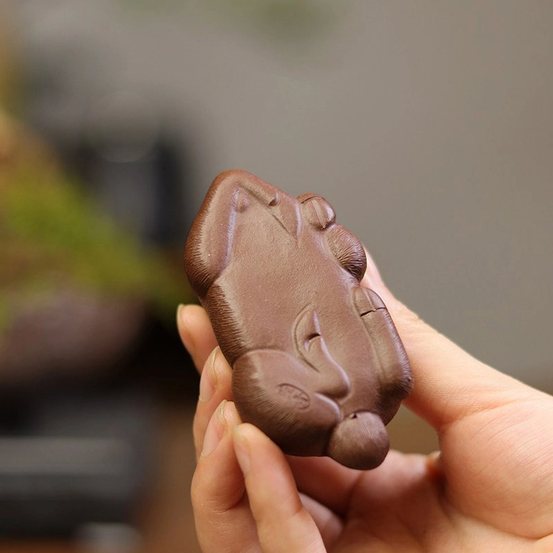 full profile view of reclining hand carved goat tea pet