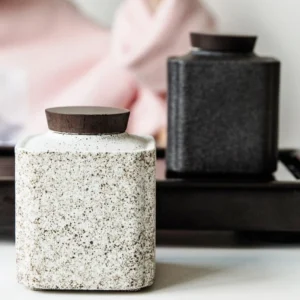 Full view of rustic ceramic tea jar with wooden lid