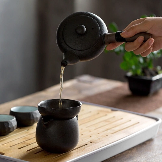 side view of black ceramic kyusu teapot showing wrapped handle