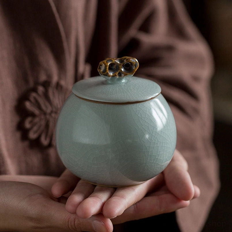 side view of round green ceramic ice crack tea jar
