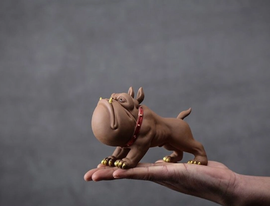 Standing French bulldog tea pet held in hand for size reference