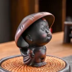 2-in-1 sprinkling little monk ceramic tea pet with tea strainer holder on wooden tea table