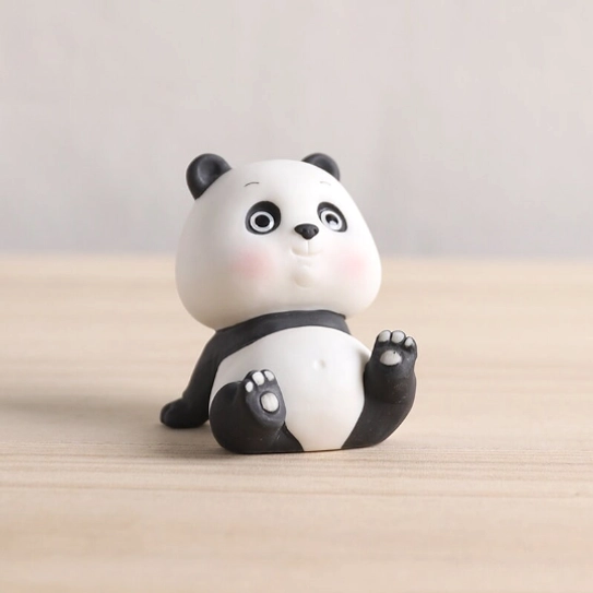 two poses of ceramic panda tea pet displayed together as office desk decor