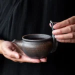 front view of vintage rustic coarse pottery gong dao bei tea pitcher