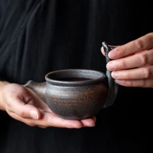 front view of vintage rustic coarse pottery gong dao bei tea pitcher