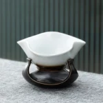 vintage petal shaped porcelain loose leaf tea strainer with black base full view