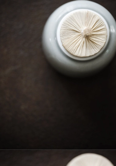 Close up of woven bamboo lid of ceramic tea jar with rope knot detail