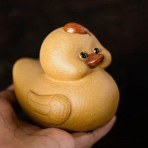 handmade yixing purple clay cute duck tea pet front view on wooden tea table