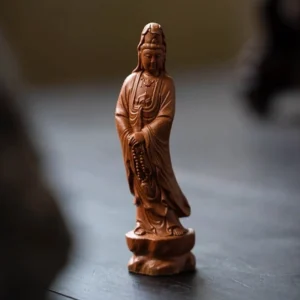 Handcrafted Yixing purple clay Guanyin Bodhisattva tea pet displayed on dark wooden tea table
