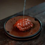Handcrafted Yixing purple clay turtle shell tea pet with lotus base on wooden tea table