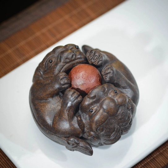 double pixiu zisha tea pet displayed on traditional bamboo tea table