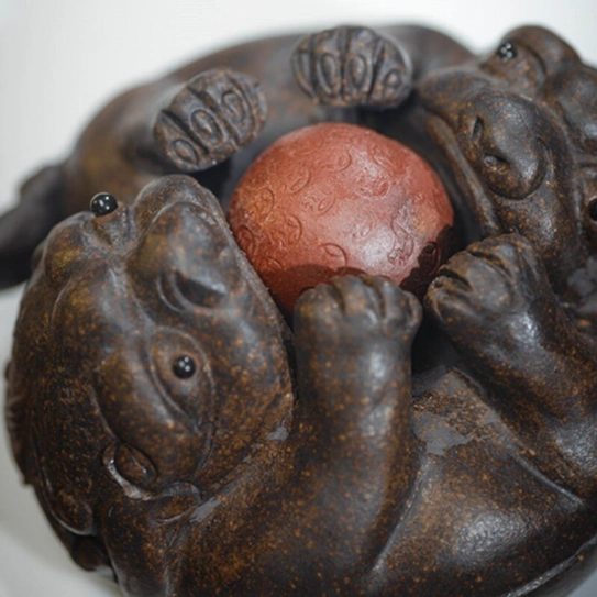 side view of double pixiu playing with lucky ball purple clay tea pet