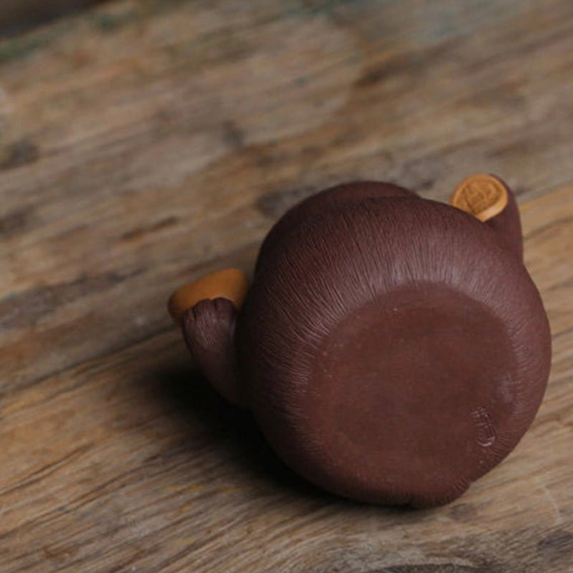 yixing zisha lucky cat tea pet closeup detail of gold ingot and copper coin